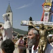 Pilgrims walk around a statue of the Blessed Virgin Mary near the church of St James in Medjugorje, Bosnia and Herzegovina (Amel Emric/AP)