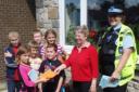 Crossways resident Hilary Percival receives her invitation from  (back) Fred Mason, Ryan Kinch and Shauna Mitchener with Megan and Liam Solly(front) and Alan Kinch helped by Vickie Hedges PSCO