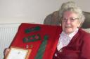 Doris Greening proudly displays her land army mementoes, medal and certificate