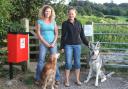 Dog walkers and their dogs celebrate the installation of a dog poo bin
