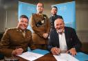 Ellis Jones Solicitors has signed the Armed Forces Covenant. Lieutenant Colonel Anthony Sharman of the British Army (left) and Managing Partner Nigel Smith (right) put pen to paper watched by Conor Maher (left) and Will Dooley (right)