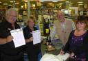 Value House staff members Tony Swatton and Yvonne Sankey with customers David Burt and Margaret Burt who is signing the petition