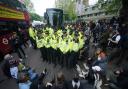 Police with protesters who formed a blockade around a coach which is parked near the Best Western hotel in Peckham, south London, to prevent the removal of migrants from the temporary accommodation