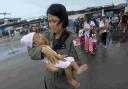 TRAGEDY: A Philippines Air Force crew member carries a baby who survived Typhoon Haiyan to an evacuation flight