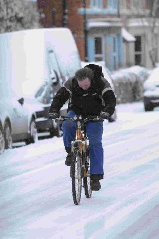 JG5562.  02.12.2010.  Snow arrives in Bridport.   On your bike.           Picture by JOHN GURD  JG5562