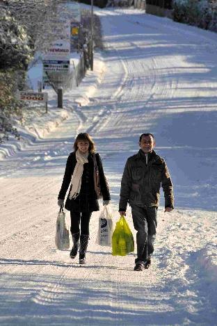 More snow in December 2010 - Lauren and Melvin Parvin walking along a snowy Poundbury Road with shopping - 181210, Picture GRAHAM HUNT HG7763