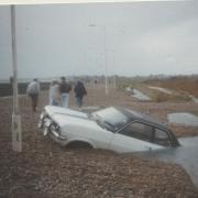 A wrecked car in the aftremath of a storm in the early 1980s that swept water and large amounts of shingle over Preston beach wall
