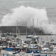 Waves crashing onto Lyme Regis' harbour wall as Storm Nelson blows in