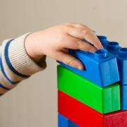 A preschool age child playing with plastic building blocks (File/PA)