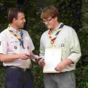 WELL DONE: First Mosterton Scouts summer gathering. Phil 'Nibby' Collier receiving The Queens Scout Award from County Commissioner Mike Parkes, left
