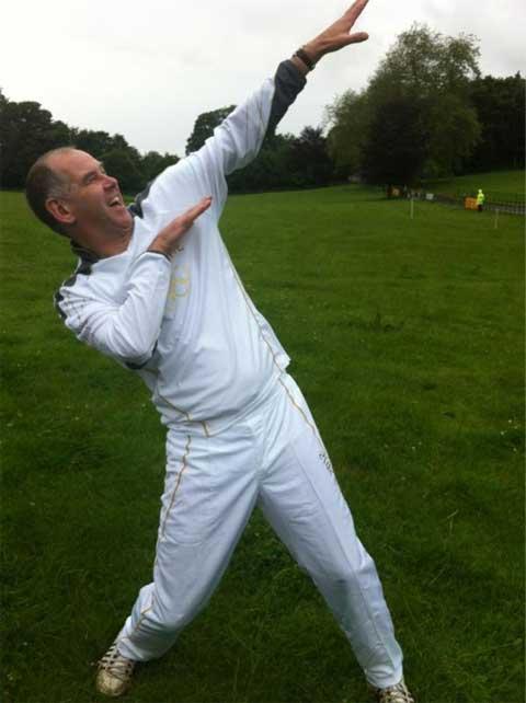 Torchbearer Andy Rimmer limbers up at Kingston Maurward‬ ‪ahead of carrying the torch through Winterboure Abbas