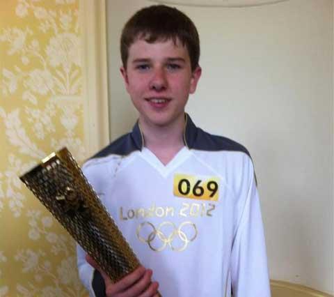 Torchbearer Tom Hartley, 15, who‬ started the relay through Winterbourne Abbas