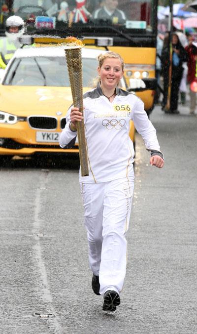 Anastasia Herring carries the Olympic Flame on the Torch Relay leg between Milborne St Andrew and Dorchester.