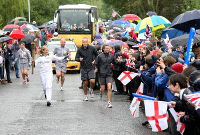 Anastasia Herring carries the Olympic Flame on the Torch Relay leg between Milborne St Andrew and Dorchester. 