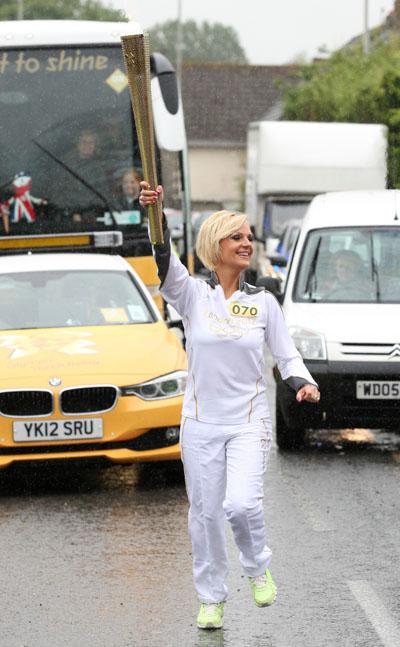 Natasha Jones carries the Olympic Flame on the Torch Relay leg between Dorchester and Winterbourne Abbas.