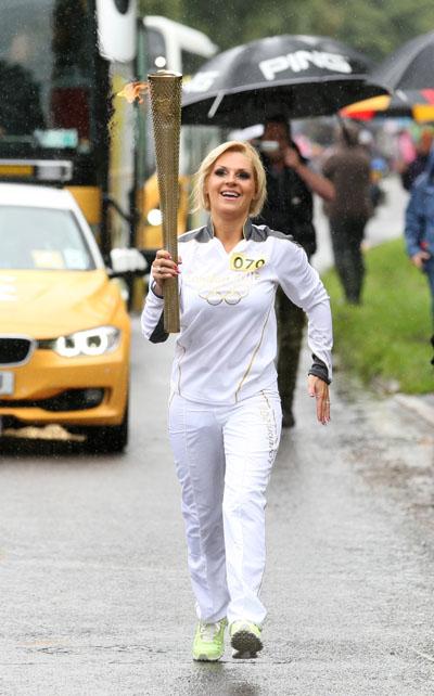 Natasha Jones carries the Olympic Flame on the Torch Relay leg between Dorchester and Winterbourne Abbas.
