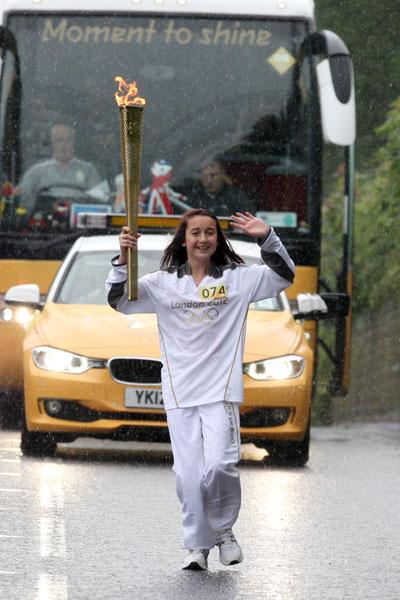  Katie Norman carries the Olympic Flame on the Torch Relay leg between Bridport and Lyme Regis. 