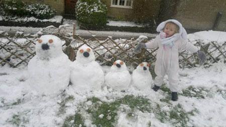 READER PHOTO: Three year old  meagan lister of Loaders with her snow men she help build of daddy, mummy ,meagan, and baby brother joshua. Photo by Brian Lister