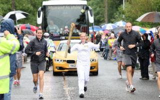 Anastasia Herring carries the Olympic Flame on the Torch Relay leg between Milborne St Andrew and Dorchester.