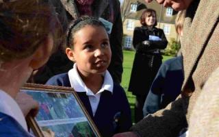 Pupils from Lulworth and Winfrith School present a picture to the Prince at the tree planting