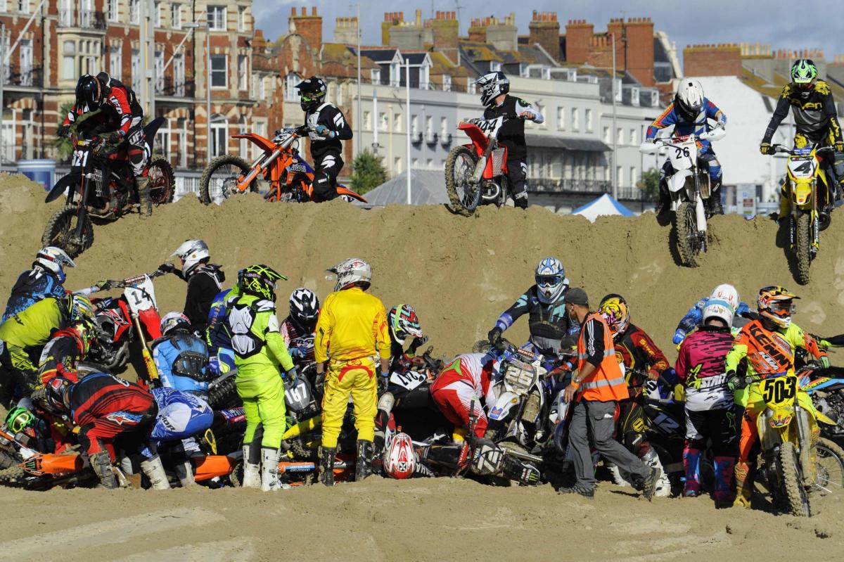 A pile up of riders and bikes on the first obstacle during the first practice run for the Weymouth Beach Motor Cross. 16th October 2016. Photo by Graham Hunt Photography.
