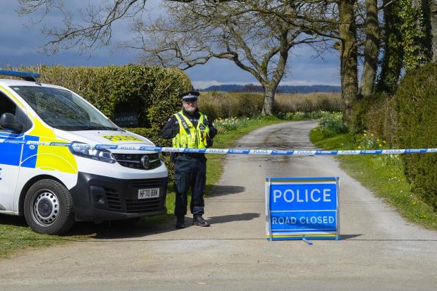 Dorset Echo: A policeman at the cordon at the entrance to the driveway which leads to the house where they are investigating Picture: Graham Hunt/BNPS