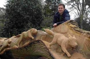 Assistant head gardener Tim Newman with the oak tree that is being sculpted by chainsaw artist Matthew Crabb