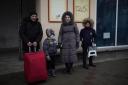 A family who fled the war from neighboring Ukraine arrive to the Przemysl train station in Przemysl, Poland, Wednesday, March 9, 2022. (AP Photo/Daniel Cole).