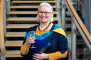 Nicola Willis-Jones celebrates with a glass of bubbly at her degree ceremony
