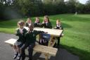 School Council members sitting on one of the four picnic tables made for and donated to the school