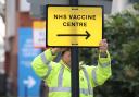 A Council worker hangs a direction sign to the NHS Covid Vaccine Centre, as ten further mass vaccination centres opened in England with more than a million over-80s invited to receive theirs