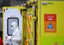 A paramedic wearing personal protective equipment (PPE) exits an ambulance outside St Thomas' Hospital in Westminster, London, as the UK continues in lockdown to help curb the spread of the coronavirus..