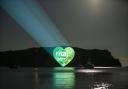 'The Fight That Unites' logo is projected onto a cliff side at Lulworth Cove in Dorset for The Great Big Green Week by The Climate Coalition, which aims to celebrate the support for climate action, to protect nature and the environment, across