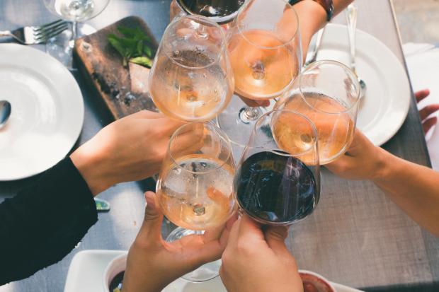 Dorset Echo: A group of people toasting with wine glasses. Credit: Canva