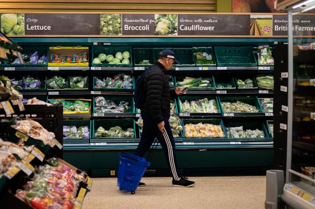 Dorset Echo: A shopper walks through the salad aisle in a branch of Tesco (PA)