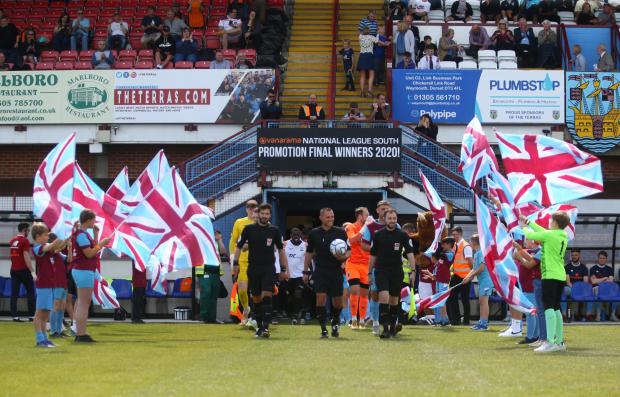 Dorset Echo: The players are greeted by mascots before the game Picture: MARK PROBIN