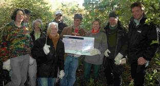 Members of the Transition Town Dorchester group on the land that has been secured for a community orchard with the £1,000 cheque donated by Stand Up Dorchester