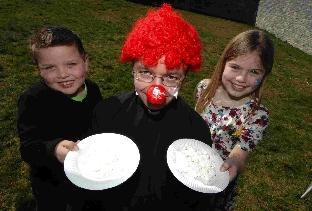 Jacob and Amelia Neubauer prepare to flan Father Darren A'Court at a fun day at St Nicholas Church in Weymouth.
