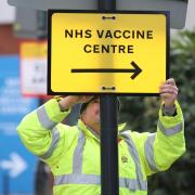 A Council worker hangs a direction sign to the NHS Covid Vaccine Centre, as ten further mass vaccination centres opened in England with more than a million over-80s invited to receive theirs