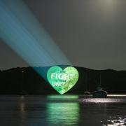 'The Fight That Unites' logo is projected onto a cliff side at Lulworth Cove in Dorset for The Great Big Green Week by The Climate Coalition, which aims to celebrate the support for climate action, to protect nature and the environment, across