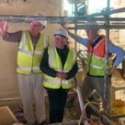 Andrew McCarthy shows Cllr Val Pothecary and Philip Martin the renovated cob walls. Picture: TOCT/Ian Cray.