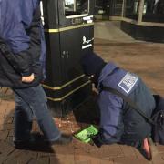 The street pastors clear away broken glass in the street so others don't get hurt