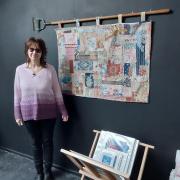 Ali Mauger with her hand stitched boro quilt, made with antique fabrics, hanging from a 1930's garden hoe