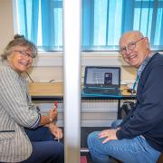 A volunteer digital champion (right) heling a resident (left) in Ferndown Library