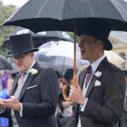 The Prince of Wales uses an umbrella to shelter from the rain during the Sovereign's Garden Party at Buckingham Palace