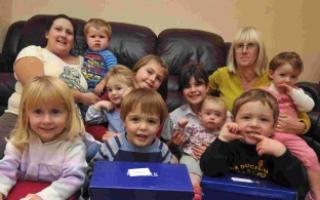 Katie and Karen Elliott and children at Dolls House childminders in Chickerell with some of their Treats for Troops boxes