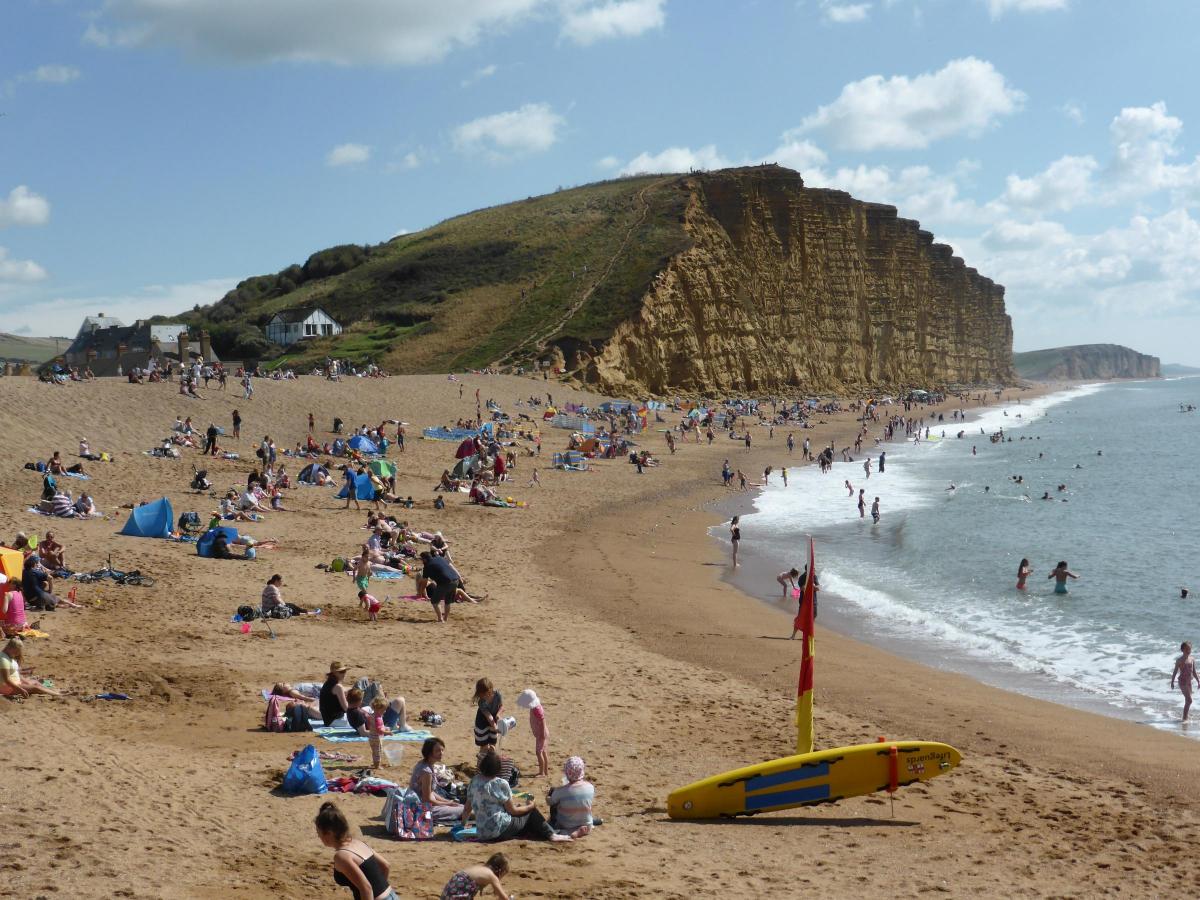 Holidaymakers enjoying the sun and surf at West Bay beach on August bank holiday August 2016 by Margaret Wellspring
