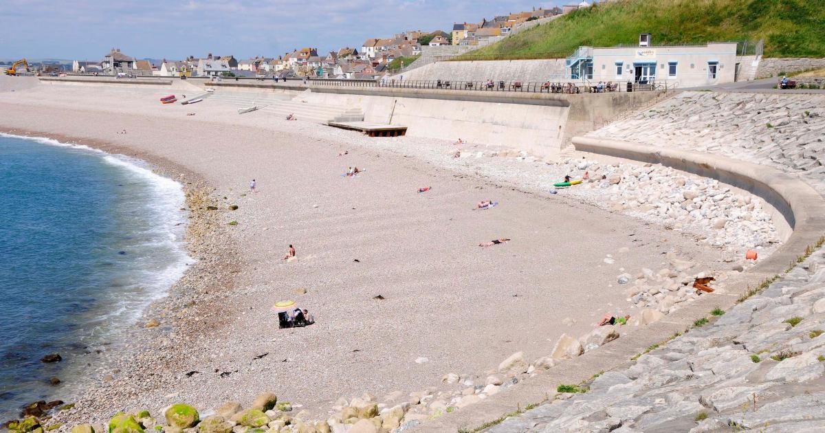 Chesil Beach. 21st August 2018. Two males enjoy swimming off Chesil Beach,  Portland, in Dorset, the